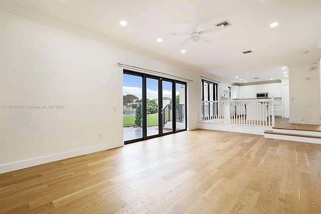 spare room with crown molding, light wood-type flooring, and ceiling fan