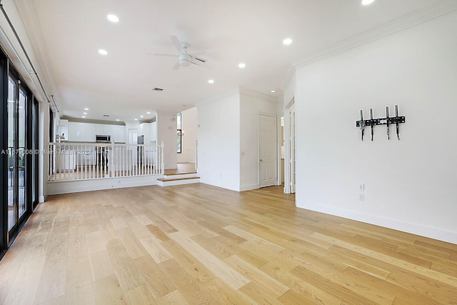 unfurnished living room featuring ceiling fan, ornamental molding, and light wood-type flooring