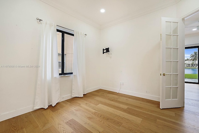 empty room featuring light hardwood / wood-style flooring and ornamental molding