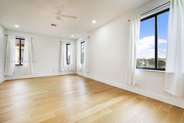 empty room with light wood-type flooring, plenty of natural light, and ceiling fan