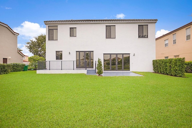 rear view of property featuring a lawn