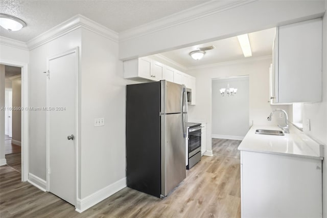 kitchen with sink, white cabinetry, light hardwood / wood-style floors, stainless steel appliances, and ornamental molding