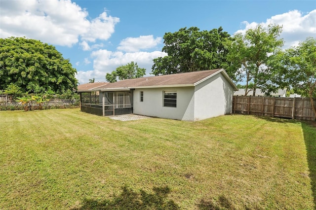 back of house with a lawn and a sunroom