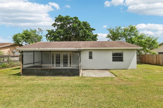 back of property featuring a sunroom and a lawn