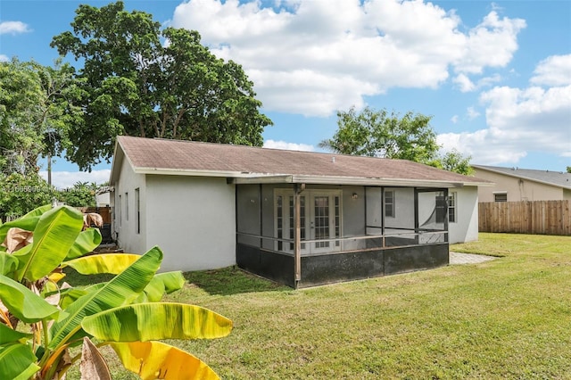 rear view of property with a yard and a sunroom