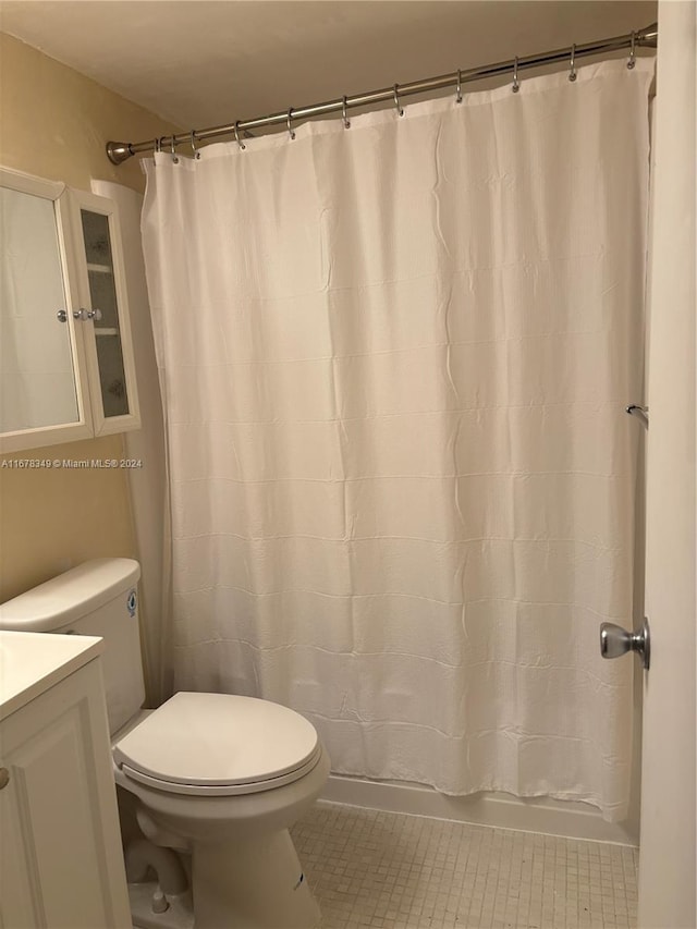 bathroom featuring tile patterned flooring, vanity, and toilet