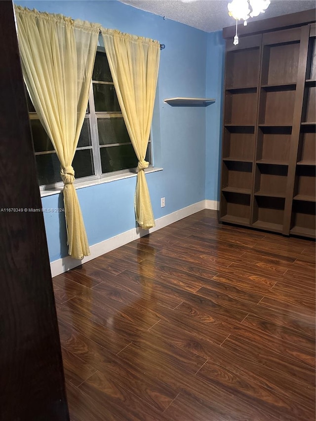 empty room with hardwood / wood-style floors and a textured ceiling