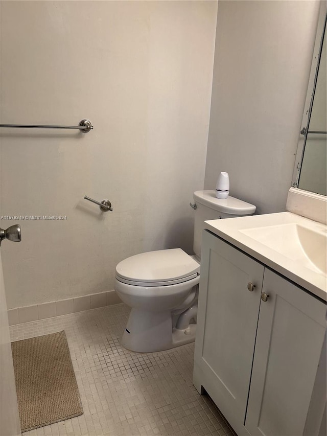 bathroom featuring tile patterned flooring, vanity, and toilet