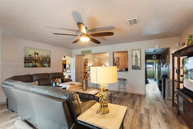 living room featuring hardwood / wood-style floors, a textured ceiling, and ceiling fan