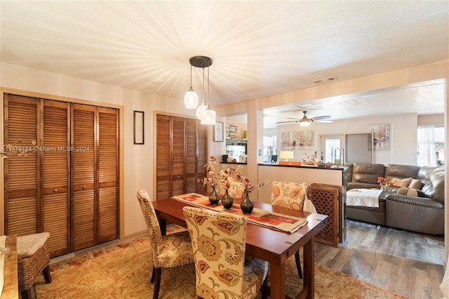 dining room with ceiling fan, a textured ceiling, and hardwood / wood-style floors