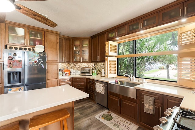 kitchen featuring decorative backsplash, appliances with stainless steel finishes, a textured ceiling, dark hardwood / wood-style floors, and sink