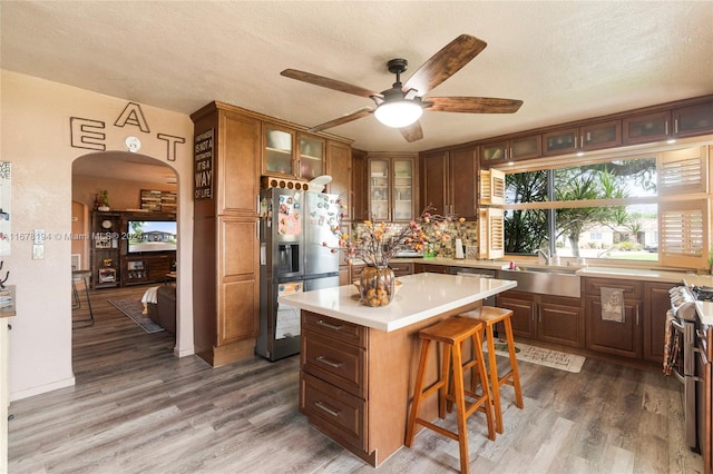 kitchen featuring a textured ceiling, appliances with stainless steel finishes, a center island, and dark hardwood / wood-style flooring