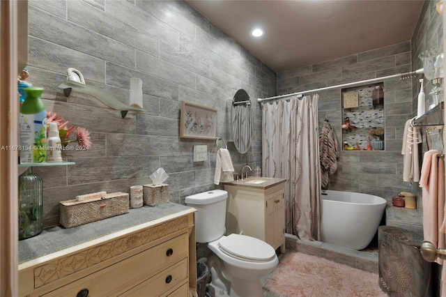 bathroom with tile walls, vanity, and toilet