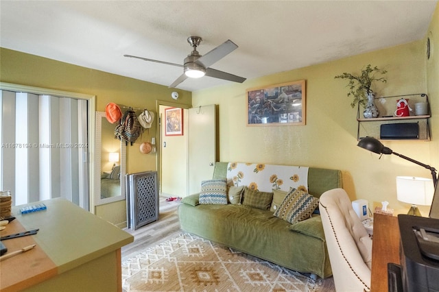 living room with light wood-type flooring and ceiling fan