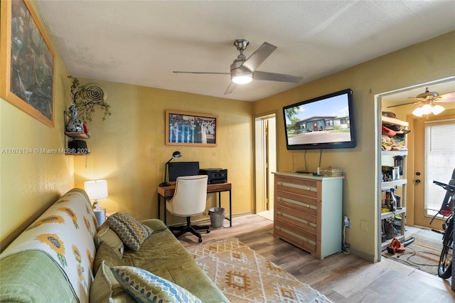 office space with a textured ceiling, light wood-type flooring, and ceiling fan