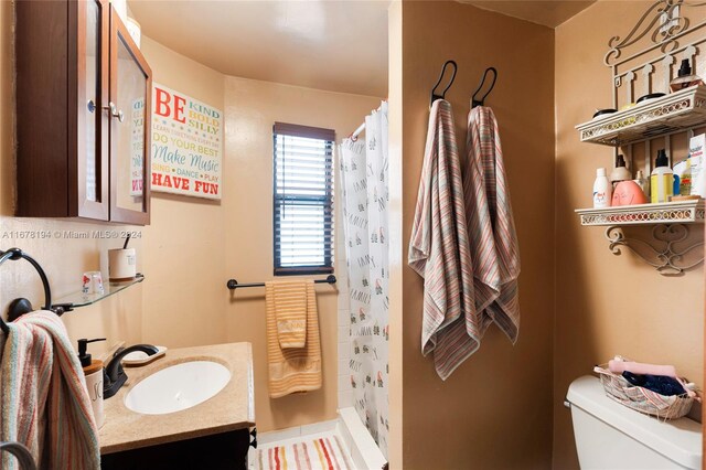 bathroom featuring vanity, toilet, and a shower with shower curtain