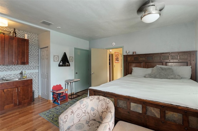 bedroom featuring a closet, sink, and light wood-type flooring