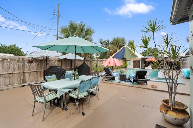 view of patio with area for grilling and a fenced in pool