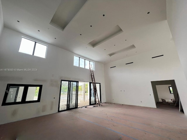 spare room with a towering ceiling and french doors