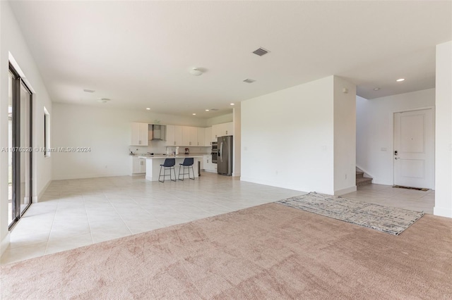 unfurnished living room with light carpet