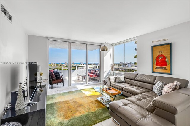 living area featuring visible vents, a wall of windows, and wood finished floors