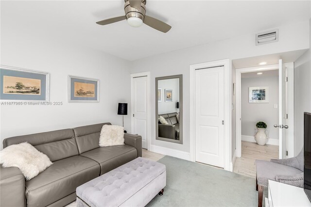 carpeted living room featuring ceiling fan