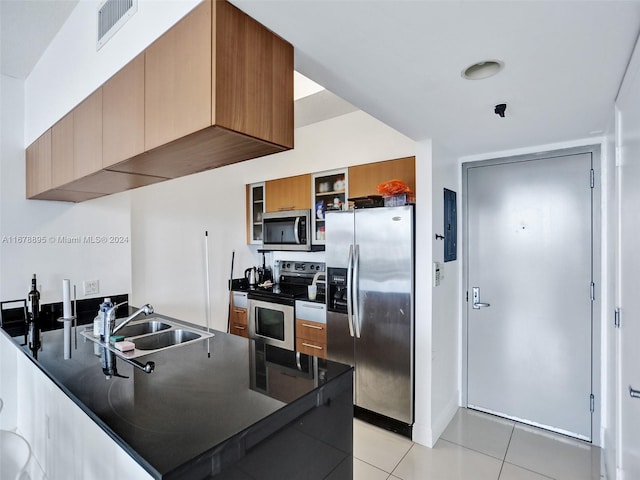 kitchen featuring sink, stainless steel appliances, and light tile patterned floors