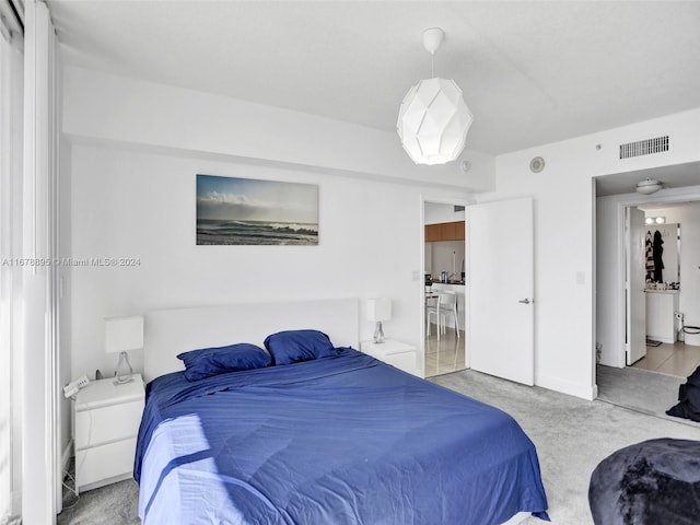 bedroom with light carpet and ensuite bath