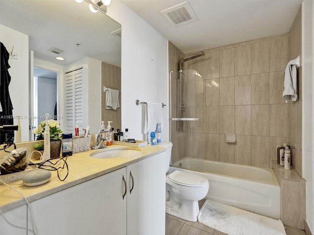 full bathroom featuring vanity, toilet, tile patterned floors, and tiled shower / bath