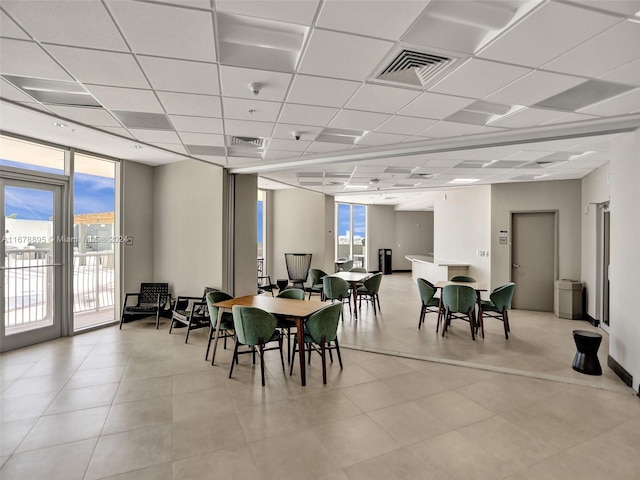 dining space featuring a drop ceiling and a healthy amount of sunlight