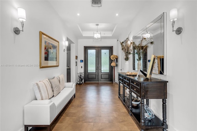 entrance foyer featuring french doors and a raised ceiling