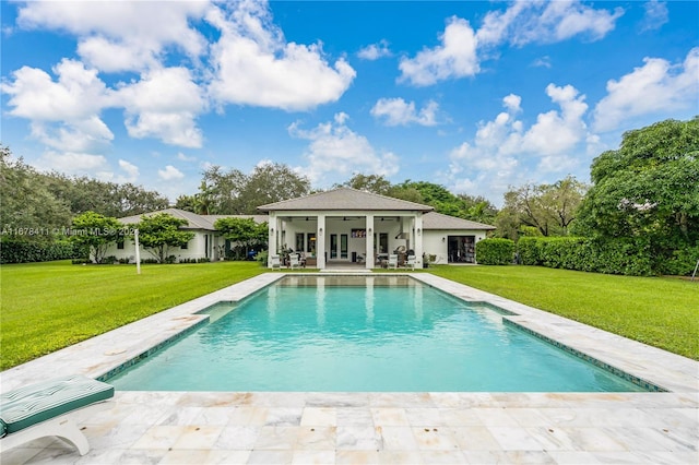 view of swimming pool featuring a patio and a lawn