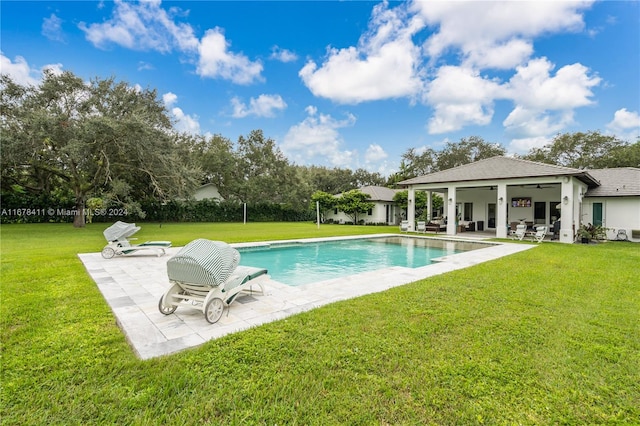 view of swimming pool featuring a patio, a lawn, and ceiling fan