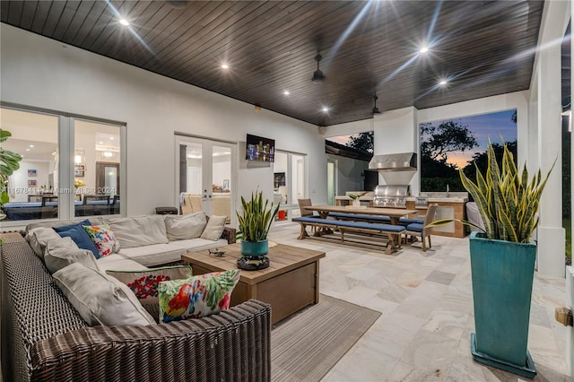 interior space with ceiling fan, exterior kitchen, and outdoor lounge area