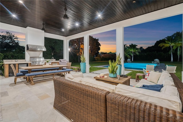 patio terrace at dusk with ceiling fan, an outdoor living space, and a grill