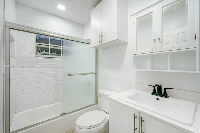 full bathroom featuring shower / bath combination with glass door, vanity, and toilet