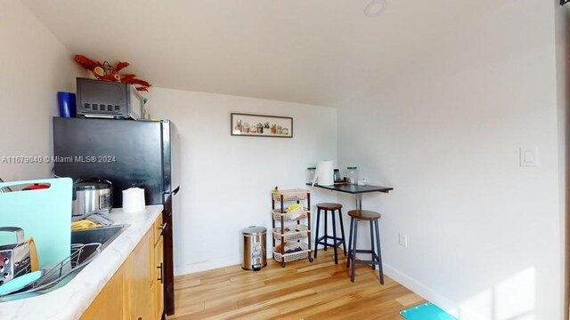 kitchen with light brown cabinetry and light hardwood / wood-style flooring