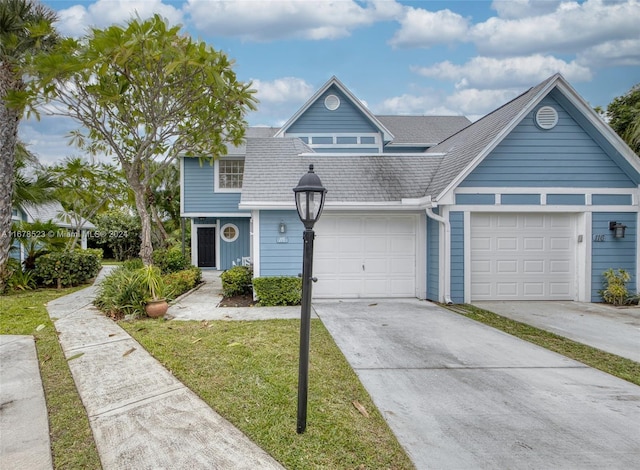 115 Ocean Dunes Cir, Jupiter, FL 33477 - view of front of house with concrete driveway, a shingled roof, and a front lawn