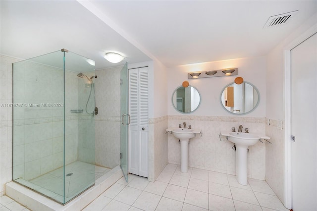 bathroom featuring tile patterned floors, tile walls, and tiled shower