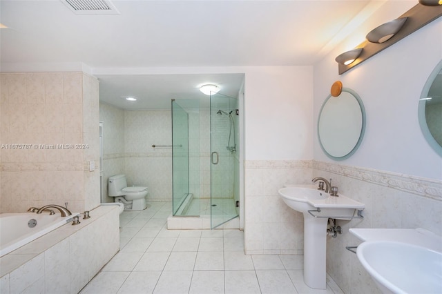 bathroom with toilet, plus walk in shower, tile walls, and tile patterned flooring