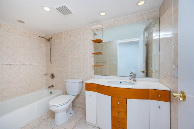 full bathroom featuring tiled shower / bath, tile walls, toilet, vanity, and tile patterned flooring