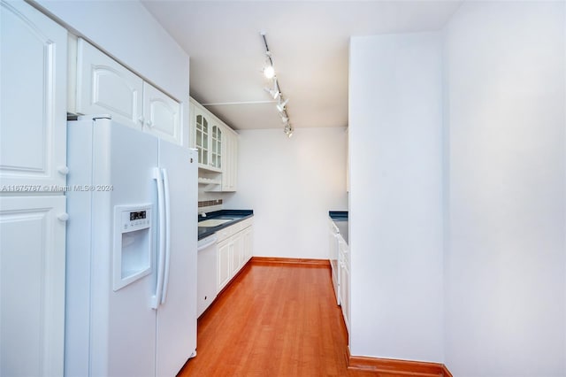 kitchen with white cabinetry, white appliances, and light hardwood / wood-style floors