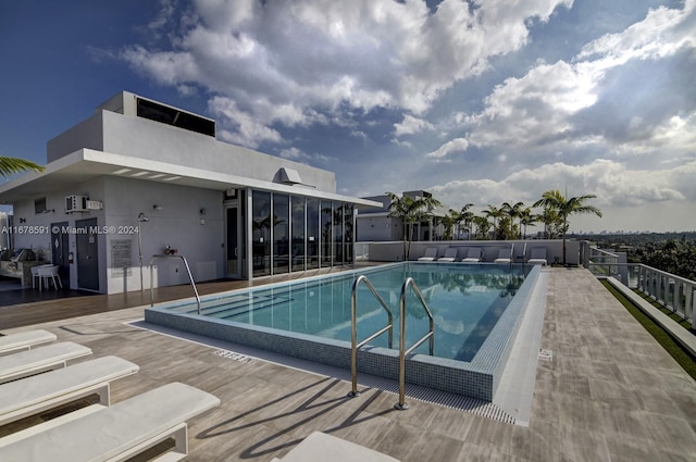 view of swimming pool featuring a sunroom and a patio area