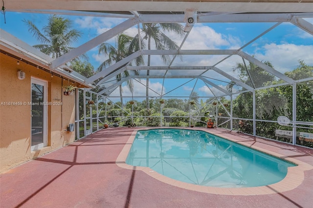 view of swimming pool featuring a patio area and a lanai