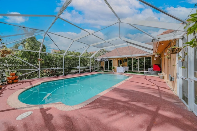 view of swimming pool featuring a patio area and a lanai