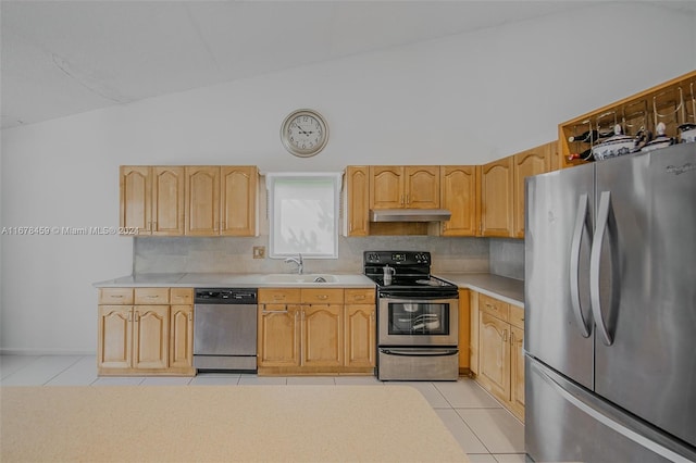 kitchen with light brown cabinetry, stainless steel appliances, vaulted ceiling, decorative backsplash, and light tile patterned floors