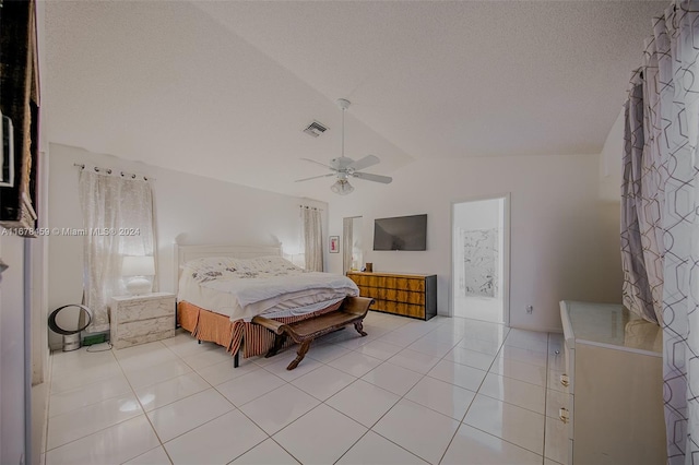 bedroom featuring lofted ceiling, a textured ceiling, light tile patterned floors, and ceiling fan