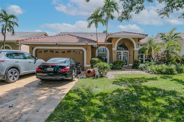 mediterranean / spanish home featuring a front lawn and a garage