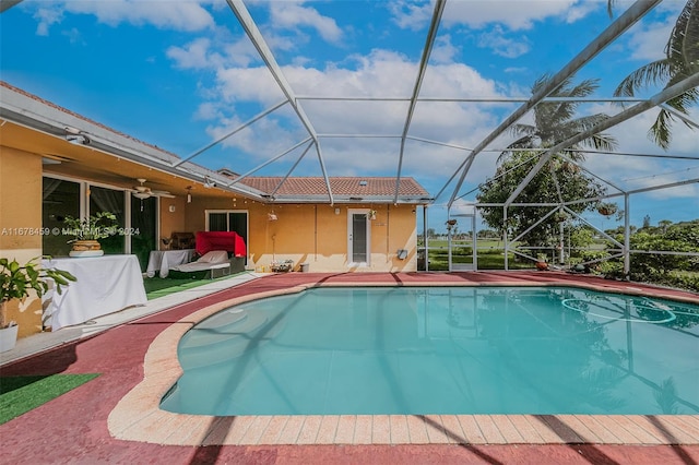 view of swimming pool featuring a patio, a lanai, and ceiling fan