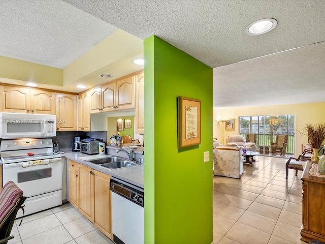 kitchen with light brown cabinets, sink, light tile patterned floors, a textured ceiling, and white appliances